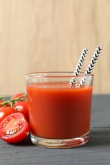 Tomato juice in a glass and fresh tomatoes on the table