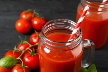 Tomato juice in a mason jar and fresh tomatoes on the table