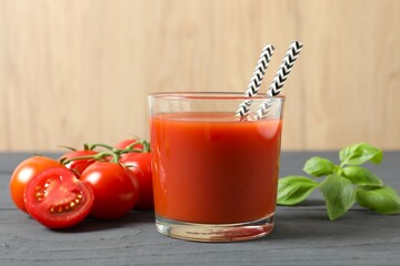 Tomato juice in a glass and fresh tomatoes on the table