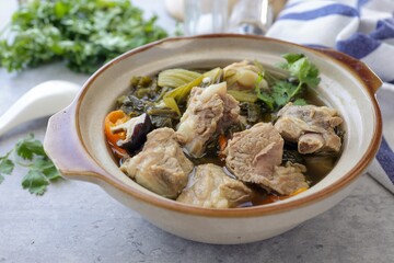 Pickled Lettuce Soup with Pork Rips in a white bowl