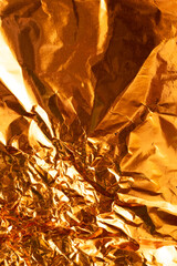 Seamless gold leaf background texture. Shiny golden yellow crumpled metallic foil repeat pattern....