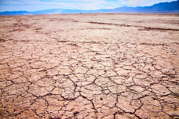 Cracked Desert Landscape with Distant Mountains Low Angle View