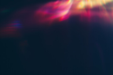 Vibrant colorful light leaks on dark blurred background. Modern design, ethereal theme, abstract visual. Retro film lens flare bokeh analog vintage photo overlay or screen filter effect