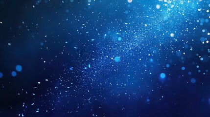 Abstract blue background with sparkling particles and bokeh lights.