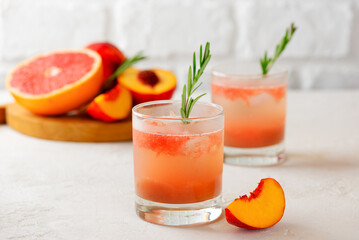Grapefruit and peach drink, tea, lemonade, cocktail with rosemary and ice. Healthy drink, sugar and alcohol free.