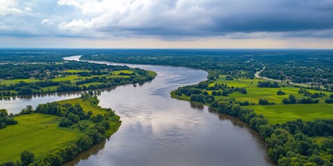 Aerial view of a winding river surrounded by lush green fields. The landscape is peaceful and natural, showcasing the beauty of the outdoors. Perfect for nature lovers and landscape photography. AI
