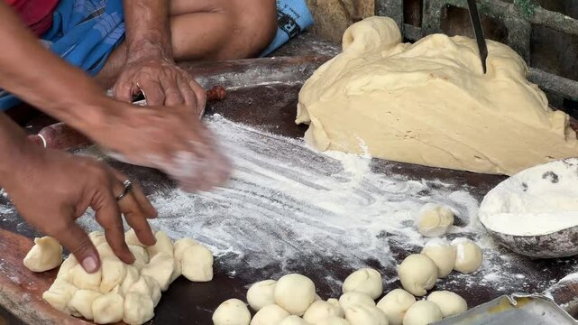 Close up shot of an old man preparing puris at a roadside stall in Kolkata, India.