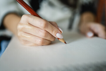 Woman sketch and draw on a blank notebook with a wooden crayon in hand