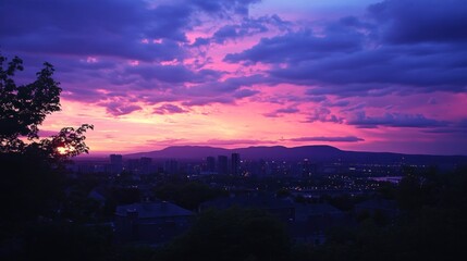 Vibrant purple and pink sunset over a city skyline.
