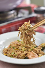 Indonesian fried noodles, with eggs and vegetables arranged in an aesthetic kitchen setting