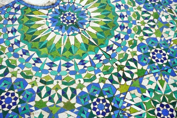 Vintage ceramic tile floor with radiating starburst pattern in green, white and blue