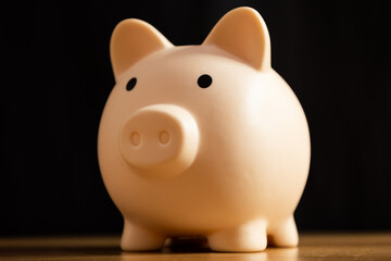Close up of piggy bank on wood with black background, concept of economy and savings © Answer 7