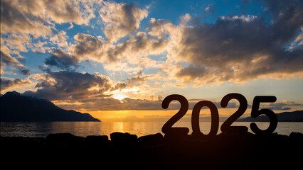 Silhouette happy new year 2025 message in starting new year 2025 concept with colorful sunrise mountains background. happy new year and holiday celebration concept.