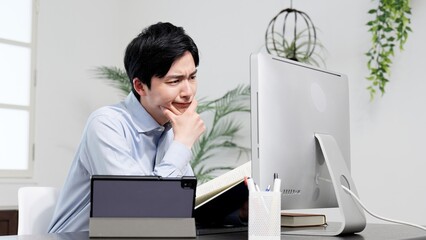 資料を調べてトラブルを解決する男性