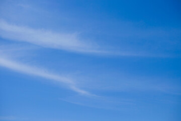Blue sky background with soft striped white clouds.Copy space. Natural abstract pattern and texture...