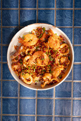 Top view, Deep-fried seafood with chili and salt in plate on blue tiled surface, Thai dish