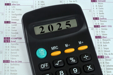 Concept de nouvelle année avec une calculatrice affichant 2025 posée sur un calendrier