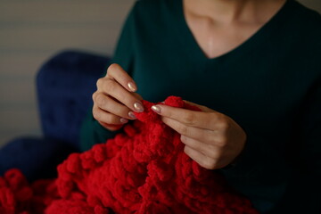 Handmade Christmas Joy: The Perfect Gift in the Making. Cozy Knitting: Christmas Blanket in the Making. Twinkling fairy lights in the background set a cozy holiday mood, pre-Christmas crafting hobbies