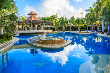 A pool with a pavilion and a small island in the middle