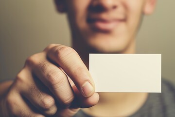 A person holds a blank business card, smiling, suggesting themes of networking, identity, or personal branding.