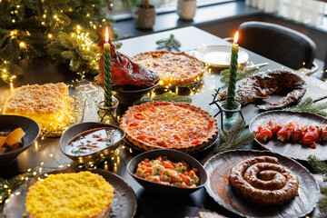 Festive table setting with Christmas decorations and burning candles in the dining room, cozy romantic Christmas in the evening atmosphere