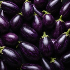 "A symmetrical pattern of purple eggplants with shiny skins on a black background."