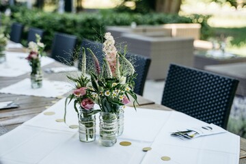 Elegant outdoor table setting with floral centerpiece.