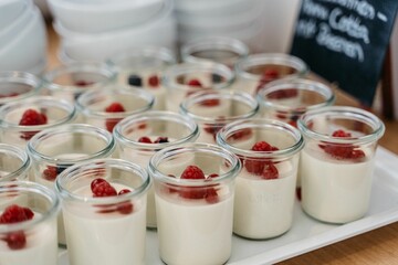 Panna cotta with raspberries in glass jars.