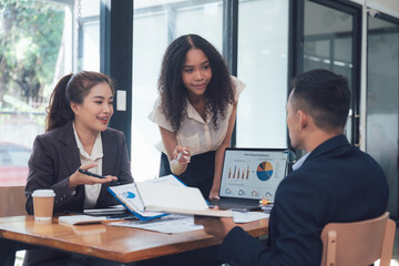 Business Meeting: A diverse team of professionals engages in a lively discussion, exchanging ideas and analyzing data, showcasing collaboration and strategic thinking in a modern office setting.