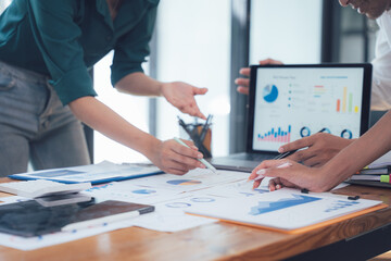 Data Driven Collaboration: Two business professionals analyze charts and graphs on a digital tablet and paper documents, showcasing a collaborative and data-driven approach to problem-solving.  