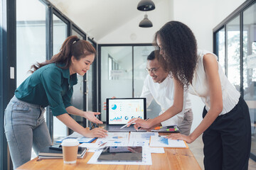 Collaborative Analysis: A diverse team of professionals gathers around a laptop, examining data and charts, engaging in a collaborative brainstorming session.