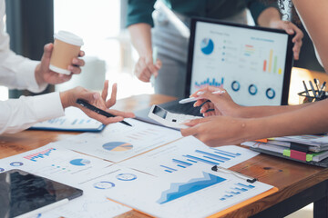 Strategic Business Meeting: Hands actively engaged in analyzing data charts and graphs during a...