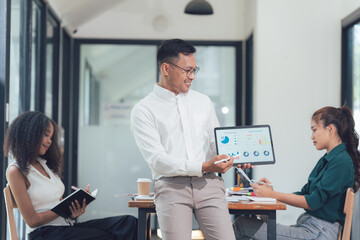 Business Presentation: A diverse team collaborates in a modern office setting, engrossed in a...