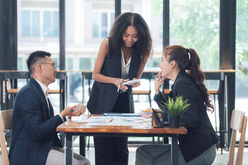 Teamwork Makes the Dream Work: Diverse business professionals collaborating on a project in a...