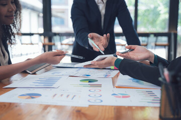 Business Team Collaboration: Close-up shot of hands exchanging documents and pens during a business meeting, showcasing teamwork and strategic planning.  