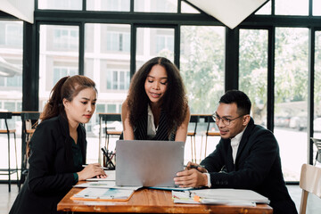 Collaborative Business Meeting:  Three diverse professionals engage in a lively discussion around a...