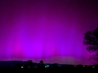 Majestic magenta and purple northern lights illuminating the night sky in La Cerdanya, Pyrenees, Spain. May 2024