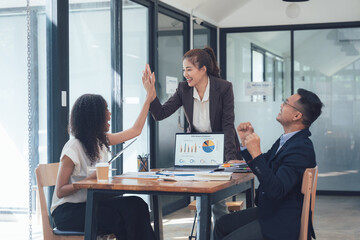 High Five for Success: A diverse team of business professionals celebrates a successful meeting, showcasing teamwork and positive energy through a high-five gesture.