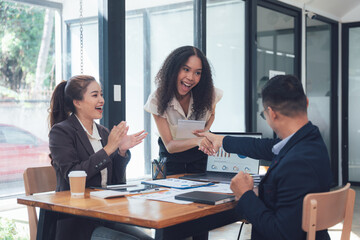Success Celebration: A diverse team of professionals celebrates a successful business meeting, their smiles radiating joy and accomplishment.  