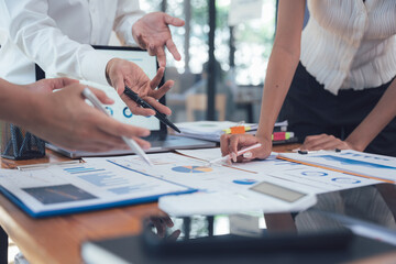 Teamwork Makes the Dream Work: A close-up shot of a team collaborating over financial documents, showcasing their dedication and strategic planning.  The image exudes professionalism and synergy.