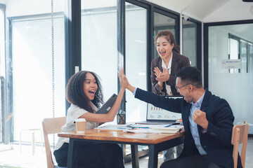 High Five, High Spirits: A diverse team celebrates a successful project with a joyful high five, radiating enthusiasm and camaraderie in a modern office setting.