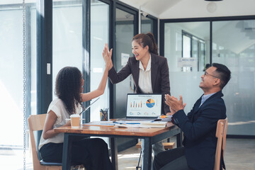 High Five Success: A diverse business team celebrates a successful meeting, sharing a high five and applause. The image captures the energy and positive vibes of collaboration and teamwork. 