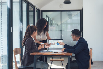 Business Meeting: A diverse team of professionals engaged in a productive discussion, analyzing...