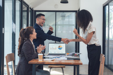 Business Deal Sealed:  A diverse team of professionals celebrates a successful deal with a handshake and joyous expressions. The image captures the spirit of collaboration, accomplishment.