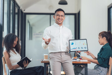 Confident Businessman Presenting Data: A charismatic businessman confidently presents data on a...