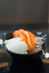 Salmon sashimi and squid sashimi served on mini bowl. Japanese food on restaurant