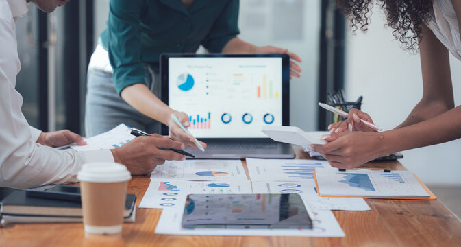 Data Driven Collaboration: A diverse team of professionals collaborate over data charts and spreadsheets, utilizing technology and insights to analyze and discuss key business metrics.  