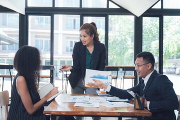 Business Meeting Collaboration: Diverse team discussing financial charts and graphs during a productive meeting in a modern office setting.  