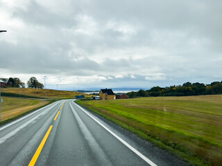 Scenic route stretching through colorful autumn landscape towards snow-capped mountain peak under clear blue sky