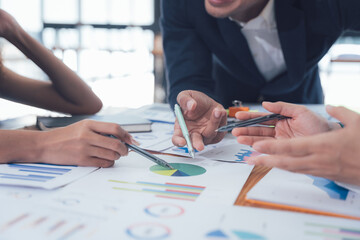 Teamwork Makes the Dream Work: A close-up shot focusing on hands actively engaged in analyzing financial charts and graphs, symbolizing collaboration, strategic planning, and successful teamwork.